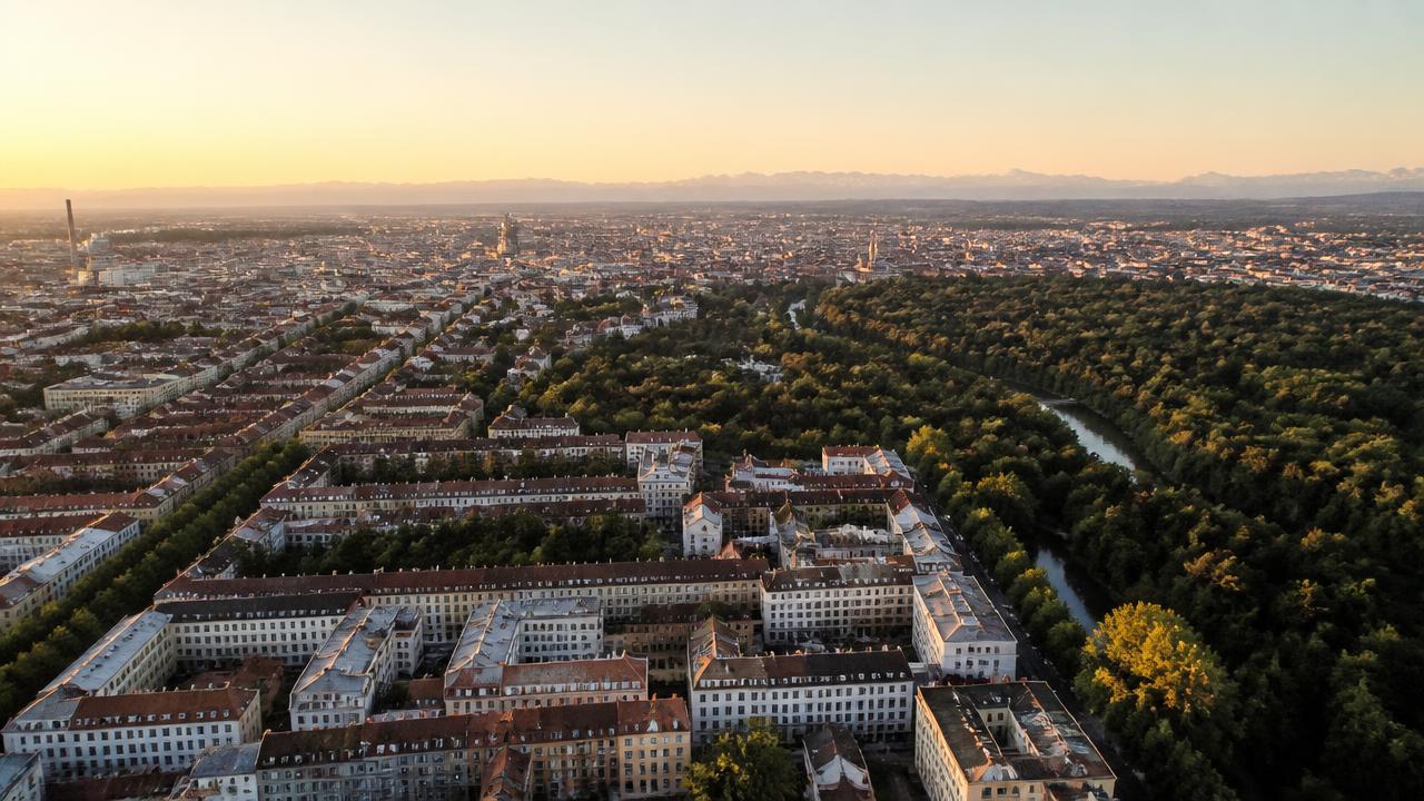 Buchhaltung München für alle Stadtteile: Luftbild über Münchner Stadtviertel mit Englischem Garten und den Alpen am Horizont